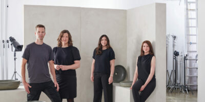 team photo with four members (left to right: Anton Vanee, Esther Vanee, Kendall Crosbie and Danielle Hacioglu) standing within the bowl collection set build in a well lit photography studio