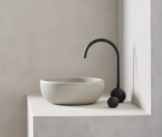 large round bowl sink rove in a micro cement minimalist bathroom in the colour bone with black hardware - photo is shot in side view