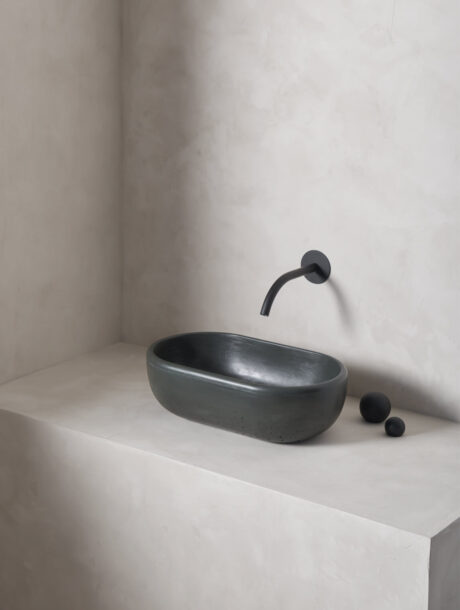 oblong turo sink in a micro cement minimalist bathroom in the colour moss with black hardware